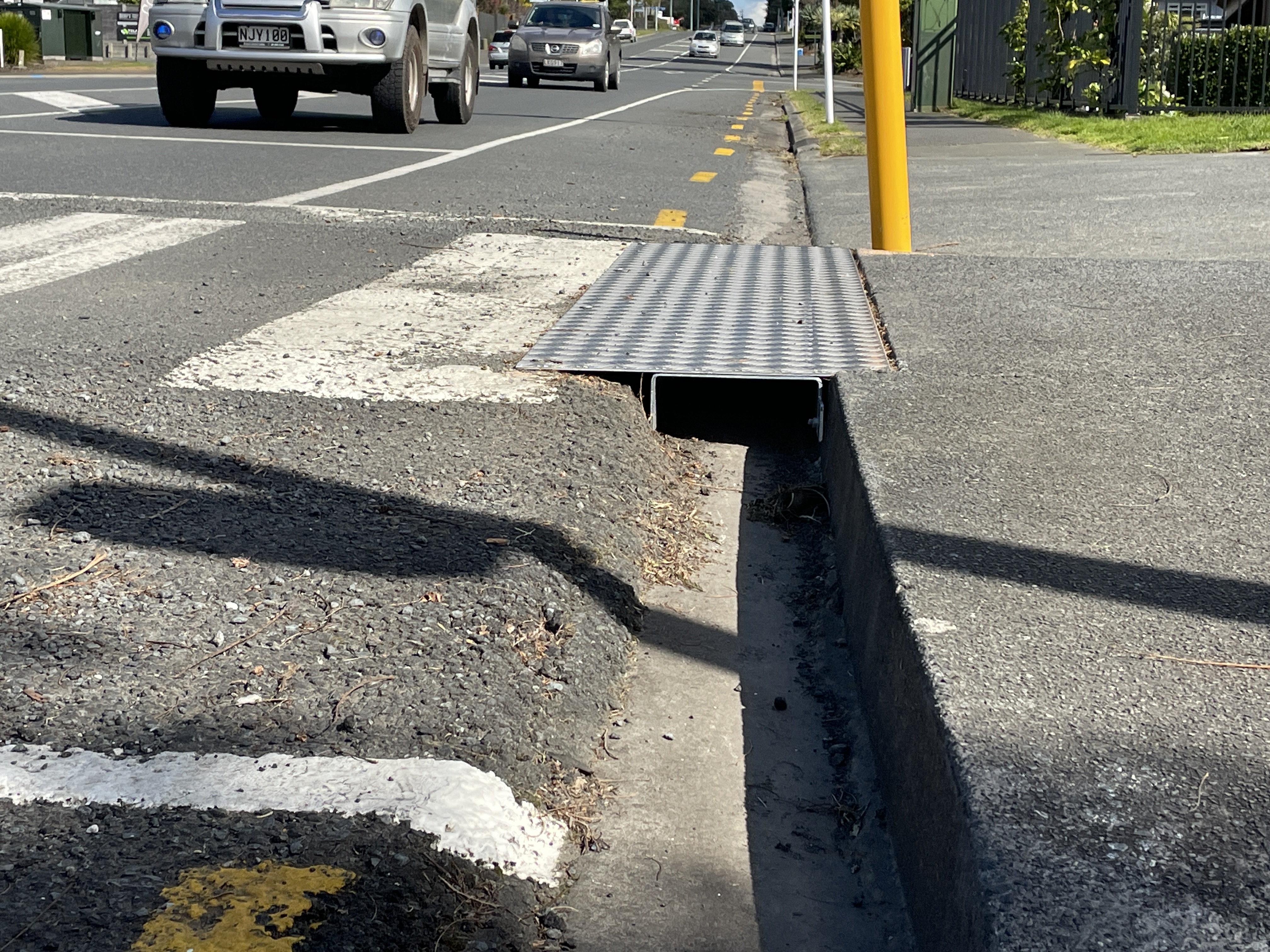 Steel u shaped reinforcement under the plates that bridge the footpath to the crossing